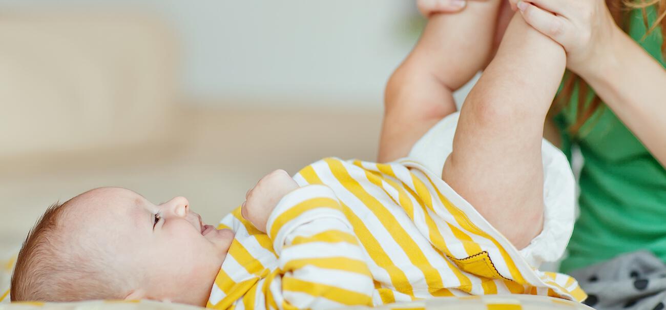 mom changing infant diaper